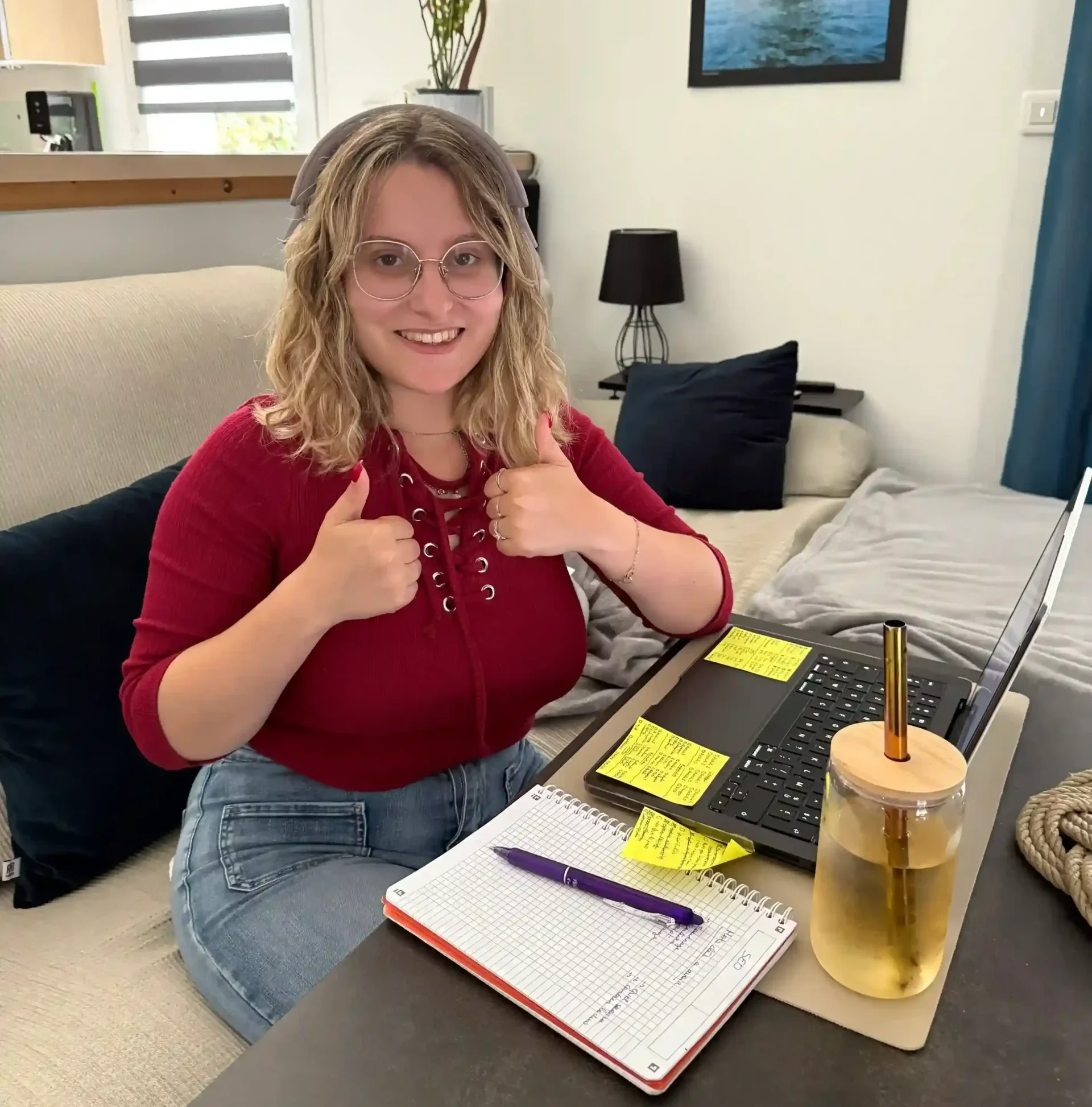Tiffanie souriante avec ses notes et son ordinateur, fière d’avoir appliqué sa formation SEO au site O3il Production avec des résultats concrets.