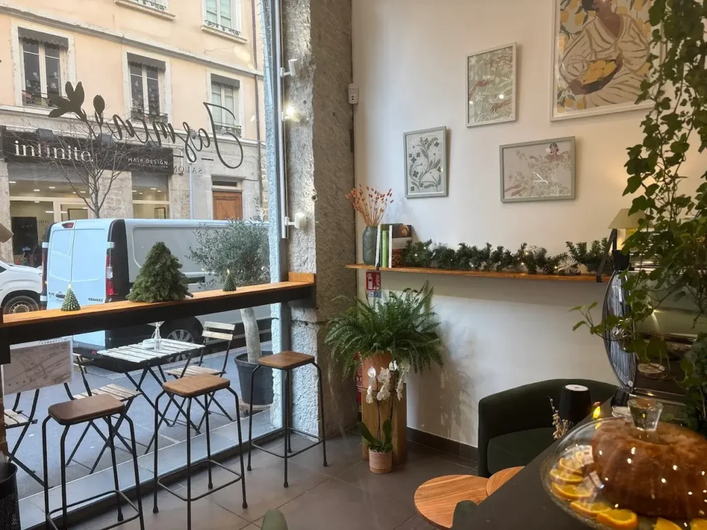 Photo d’un salon de thé à Lyon avec tables, tabourets et décoration végétale, mon arrivée chez O3il Production