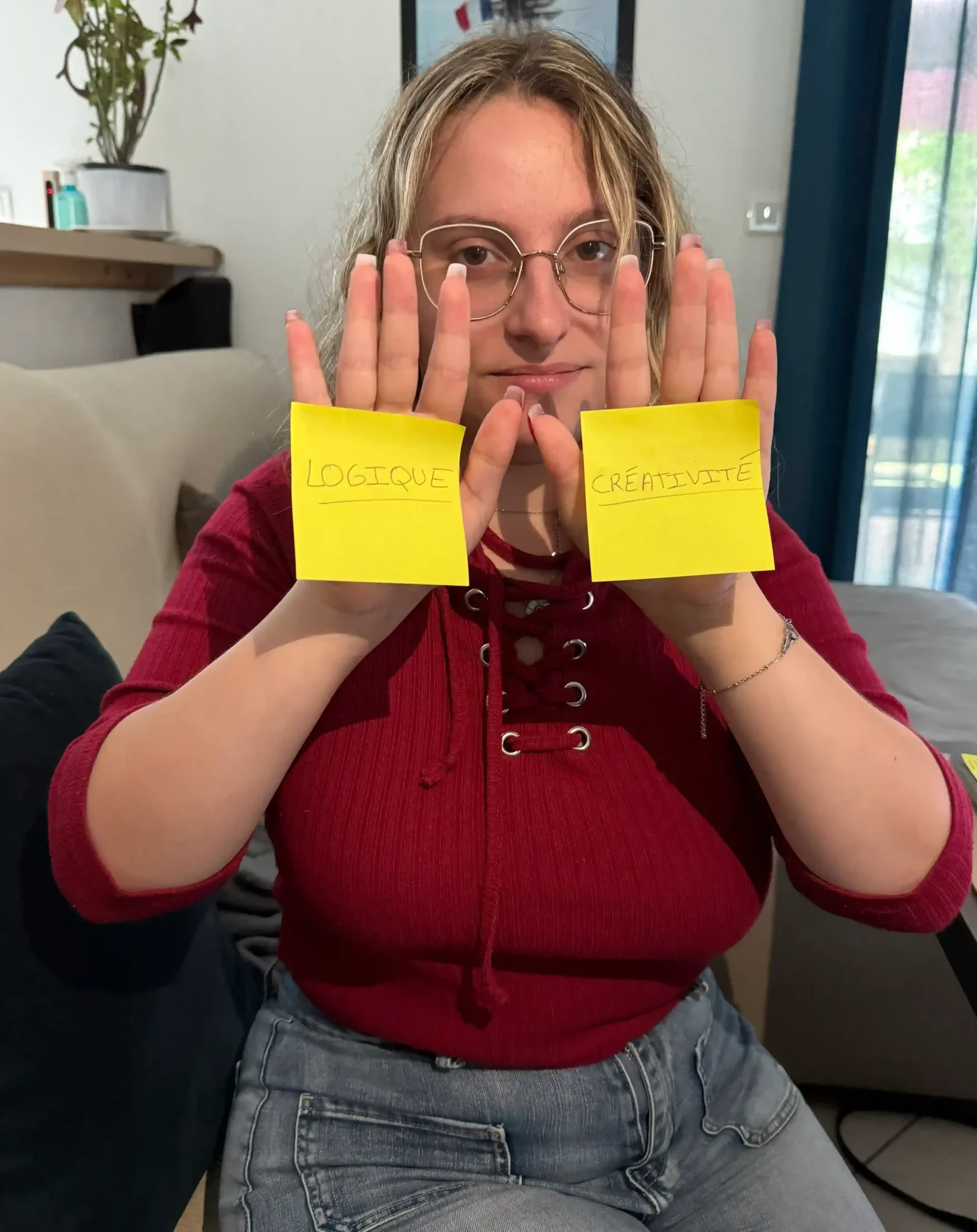 Tiffanie tient deux post-it marqués « logique » et « créativité », symbolisant l’équilibre nécessaire pour réussir une stratégie SEO.