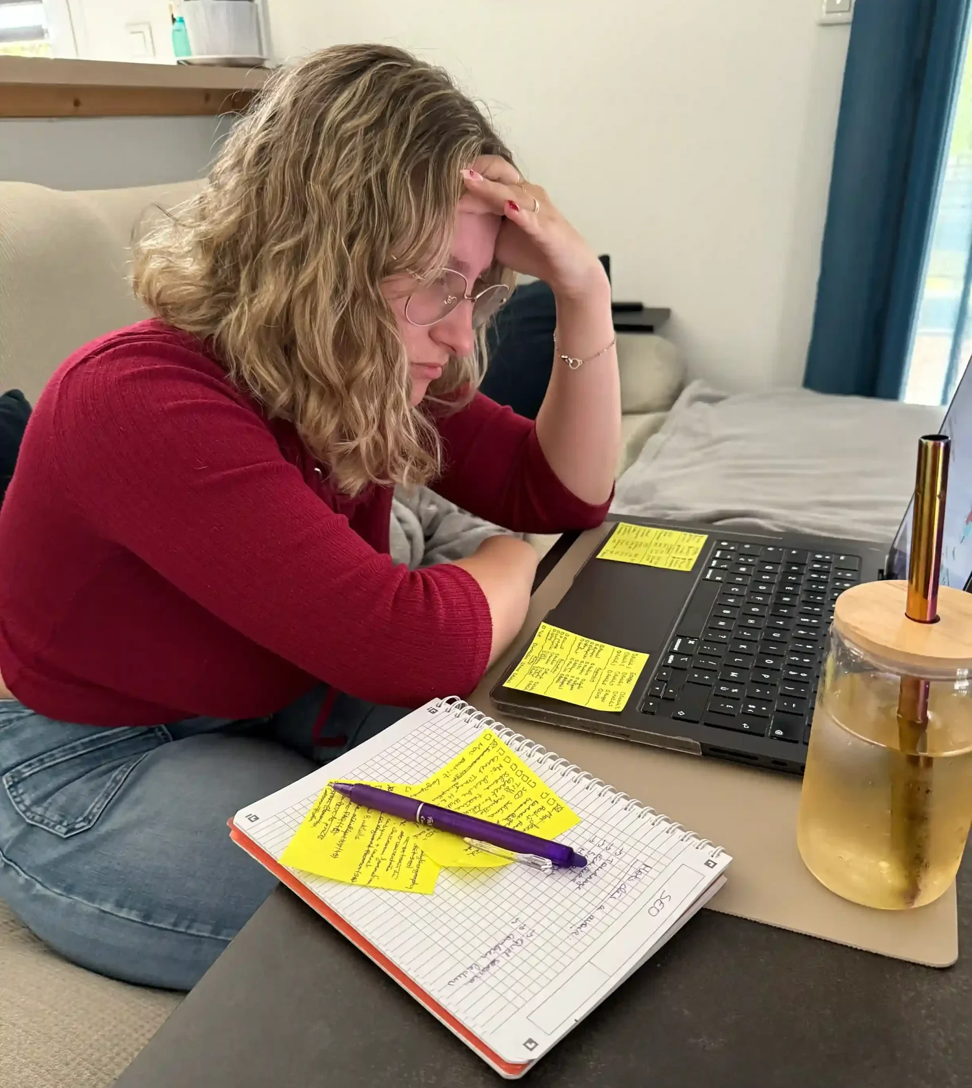 Tiffanie concentrée devant son ordinateur, entourée de notes et post-it, découvrant les bases parfois difficiles du SEO.