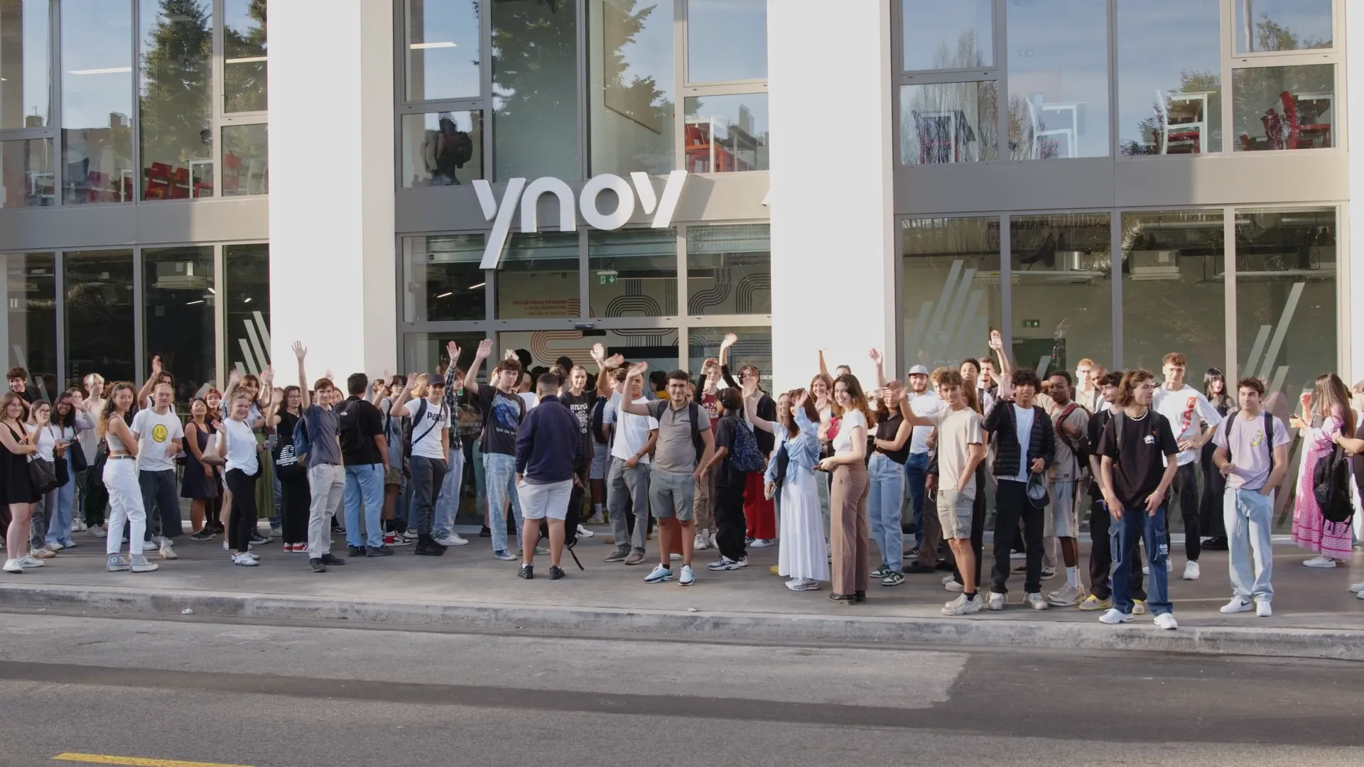 Groupe d’étudiants réunis devant le campus Ynov, symbole de dynamisme et de vie étudiante.